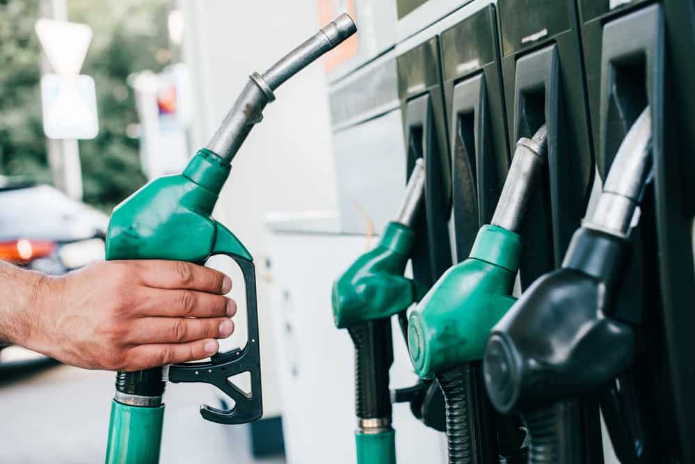 Cropped view of man holding fueling nozzle on gas station