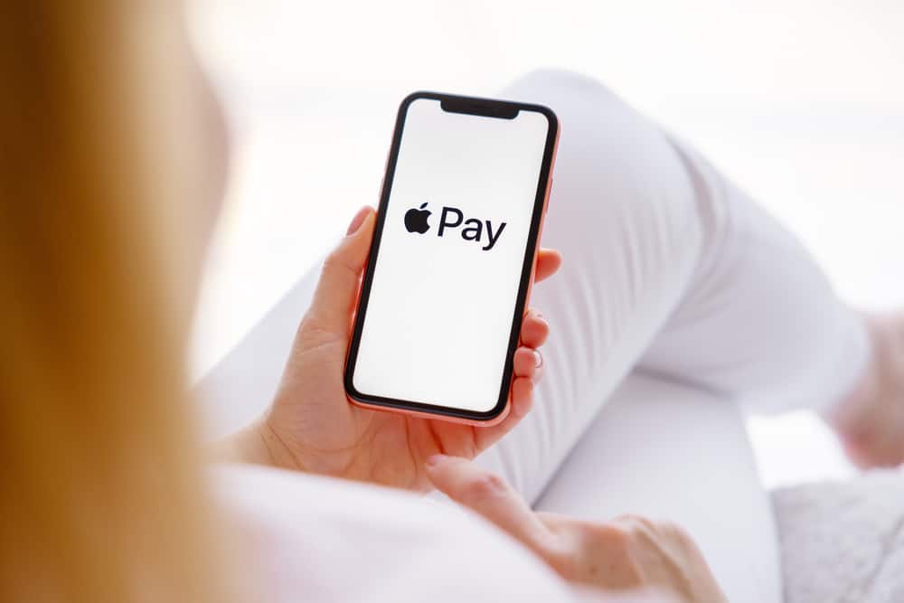 Woman holding phone with Apple Pay logo on the screen