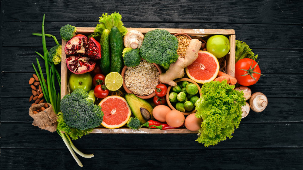 Fresh vegetables, nuts and fruits in a wooden box