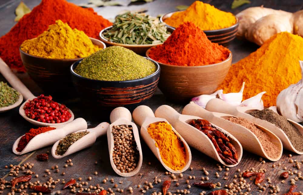 Variety of spices and herbs on kitchen table.